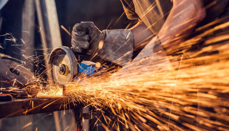 Close-up of worker cutting metal with grinder